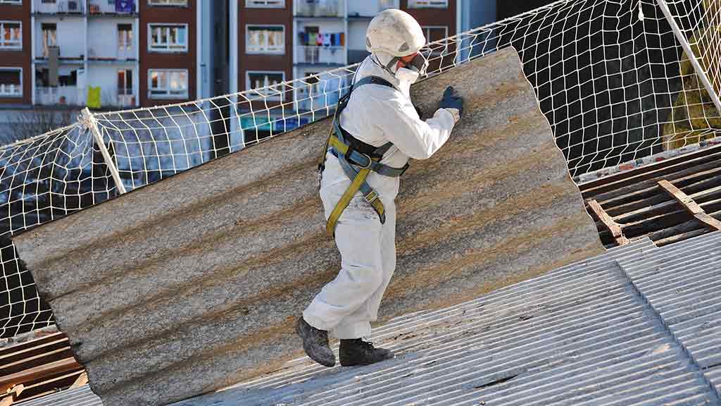 Gefahren am Arbeitsplatz Mitarbeiter Schutzanzug Maske Steigung Dach schwere Arbeitsplatte