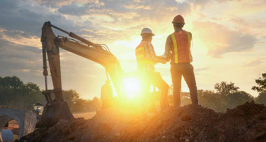 Bauherren bei Planungsarbeiten auf der Baustelle ihres neuen Unternehmens