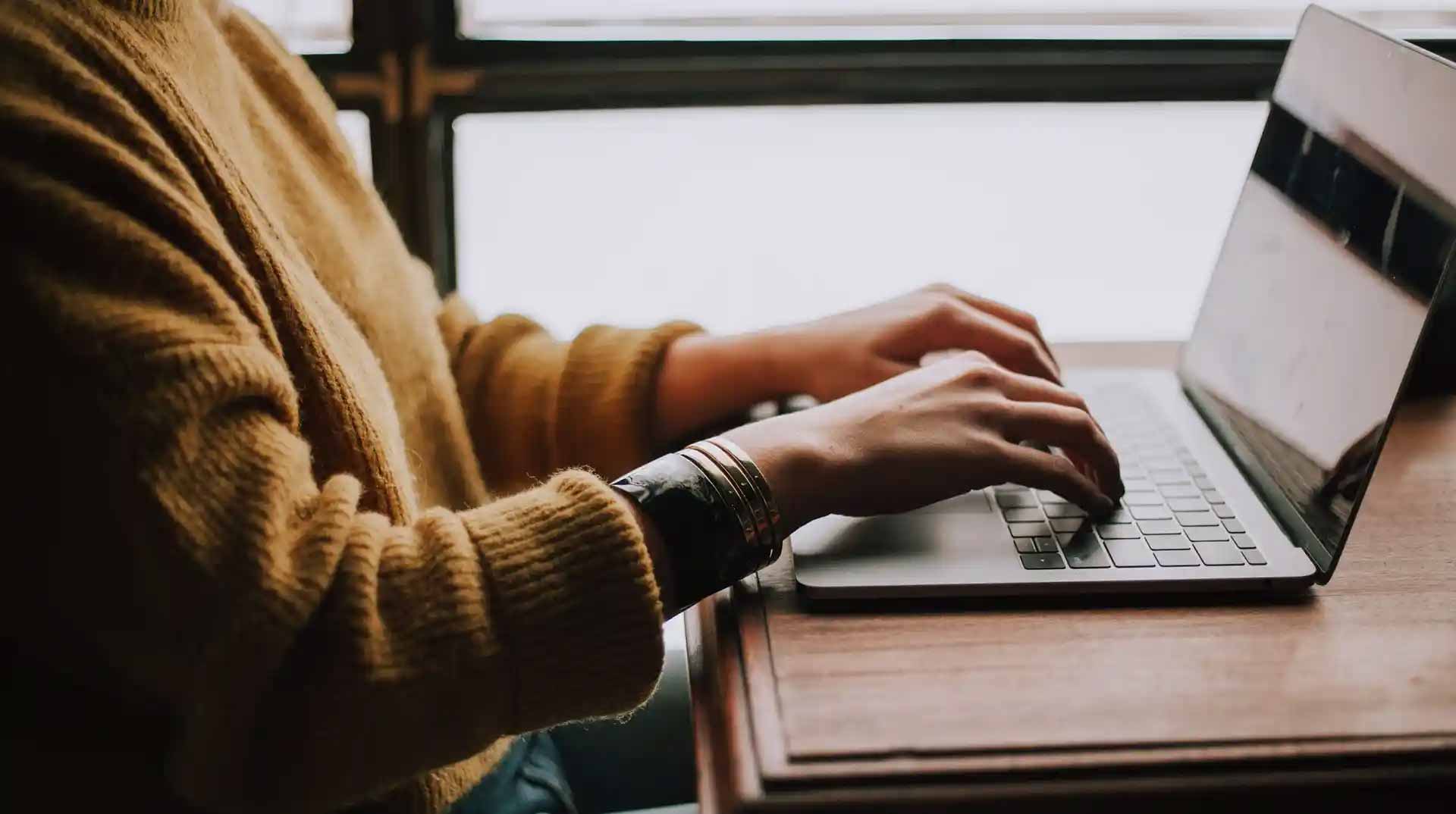 Mann sitzt am Schreibtisch vor seinem Laptop und erstellt eine e-Learning Schulung