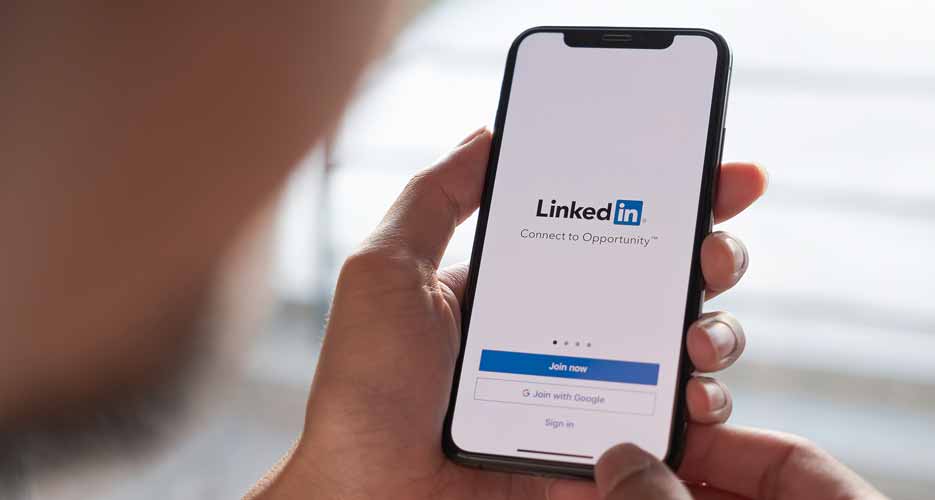 Nutzer öffnet die LinkedIn App auf seinem Smartphone